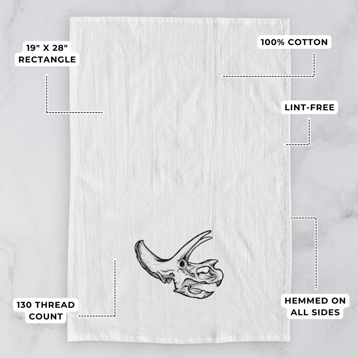 White tea towel printed with a detailed black ink illustration of a Triceratops skull with its horns and frill, with feature labels: 19 by 28 inch rectangle, 100% cotton, lint-free, 130 thread count, hemmed on all sides.