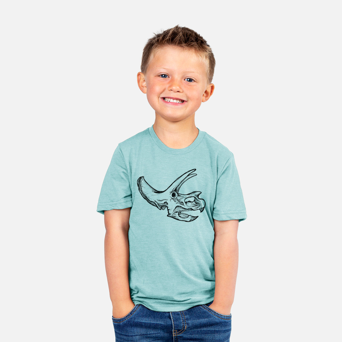Smiling boy wearing a youth t-shirt printed with a detailed black ink illustration of a Triceratops skull with its horns and frill.
