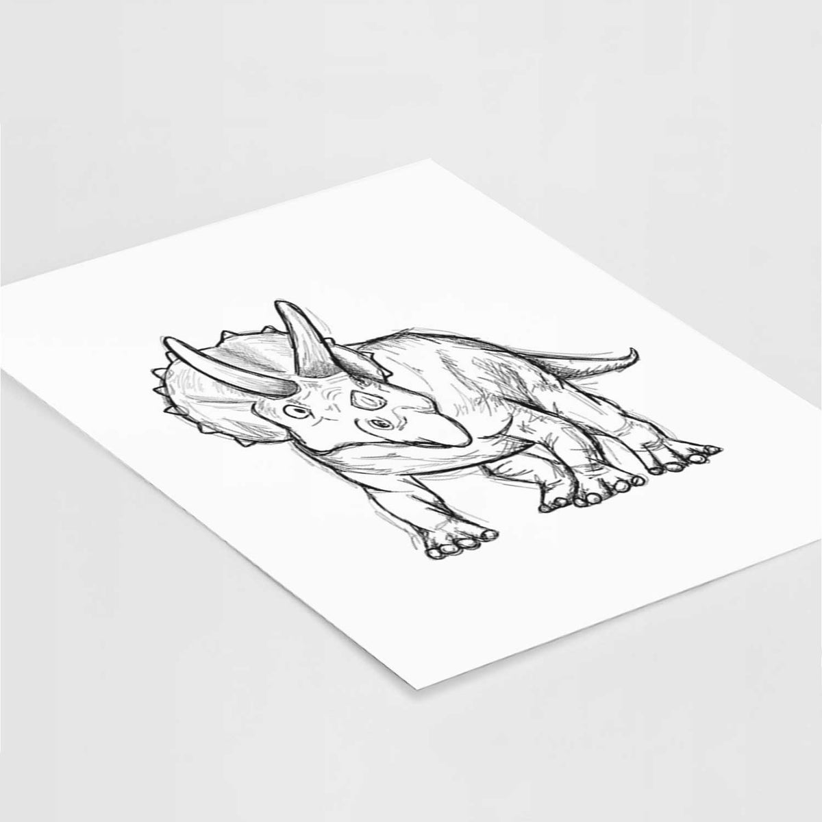 Art print of a black ink illustration of a Triceratops walking, lying at an angle on a white surface.