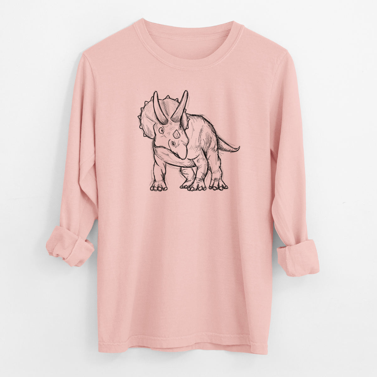 Peachy Comfort Colors long sleeve shirt laid flat with the cuffs rolled, printed with a black ink illustration of a Triceratops walking.