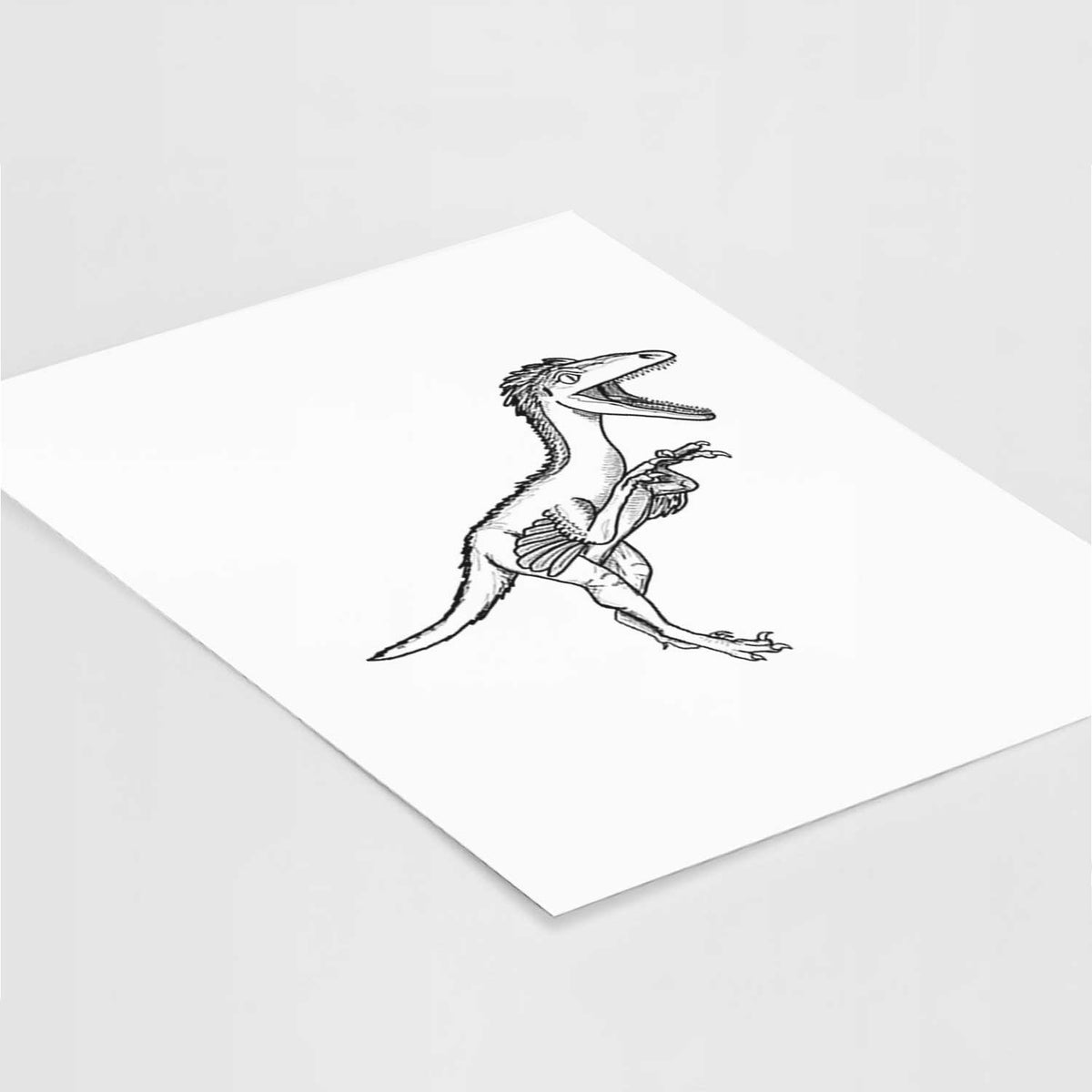 Art print of a black ink illustration of a Troodon dinosaur running, lying at an angle on a white surface.