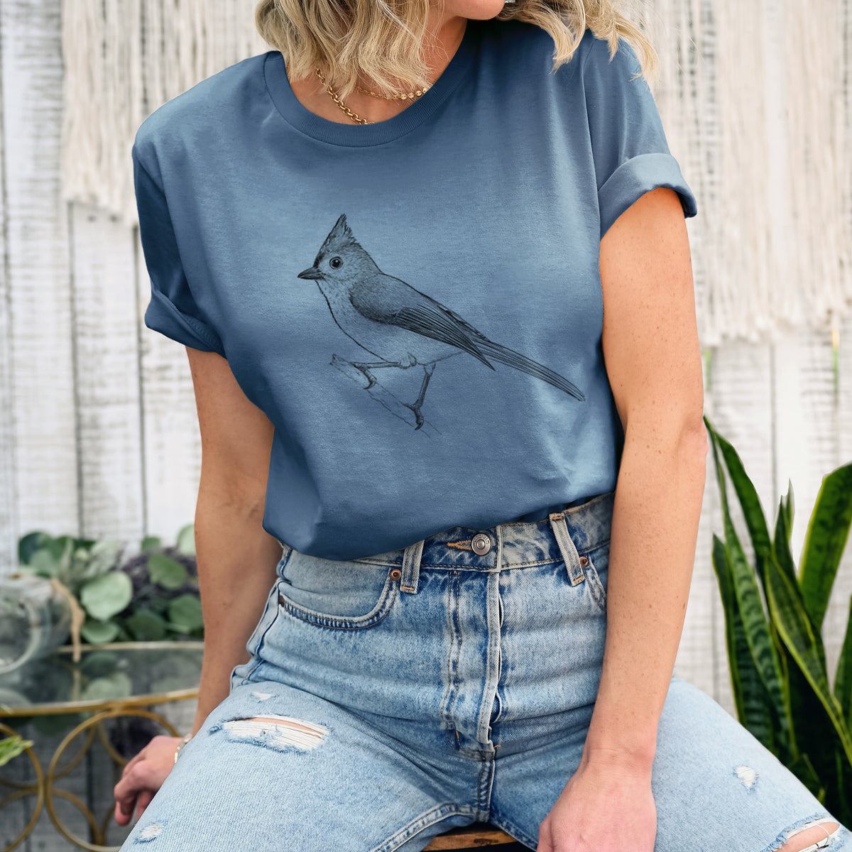 Woman wearing a steel blue lightweight cotton t-shirt printed with a detailed black ink sketch of a tufted titmouse perched on a branch.