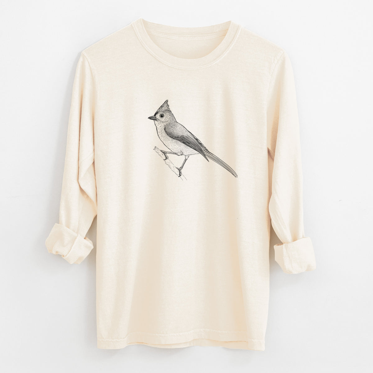 Ivory Comfort Colors long sleeve shirt laid flat with the cuffs rolled, printed with a detailed black ink sketch of a tufted titmouse perched on a branch.