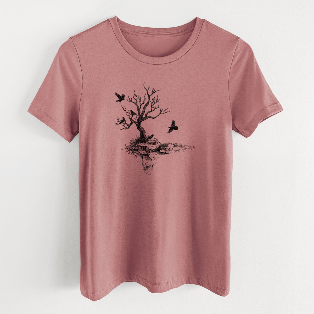 Mauve pink women's relaxed fit cotton t-shirt laid flat, printed with a black ink illustration of a bare twisted tree on a small island with ravens flying around it.