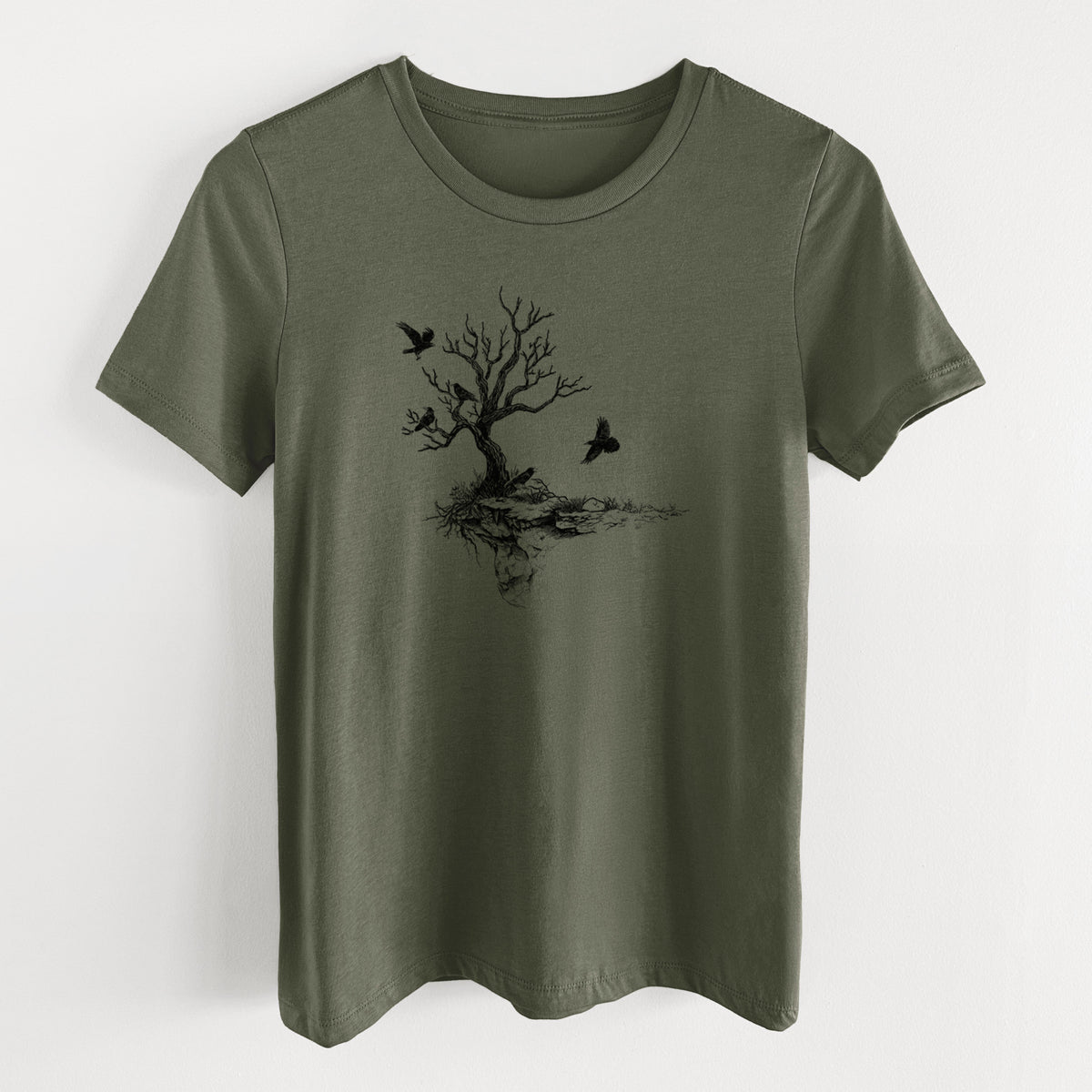 Military green women's relaxed fit cotton t-shirt laid flat, printed with a black ink illustration of a bare twisted tree on a small island with ravens flying around it.