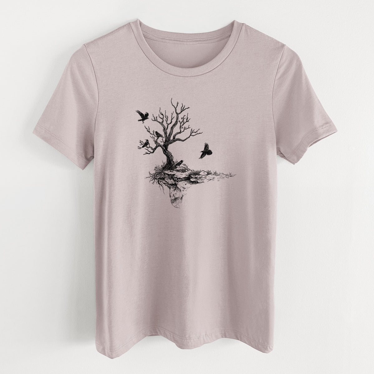 Pink gravel women's relaxed fit cotton t-shirt laid flat, printed with a black ink illustration of a bare twisted tree on a small island with ravens flying around it.