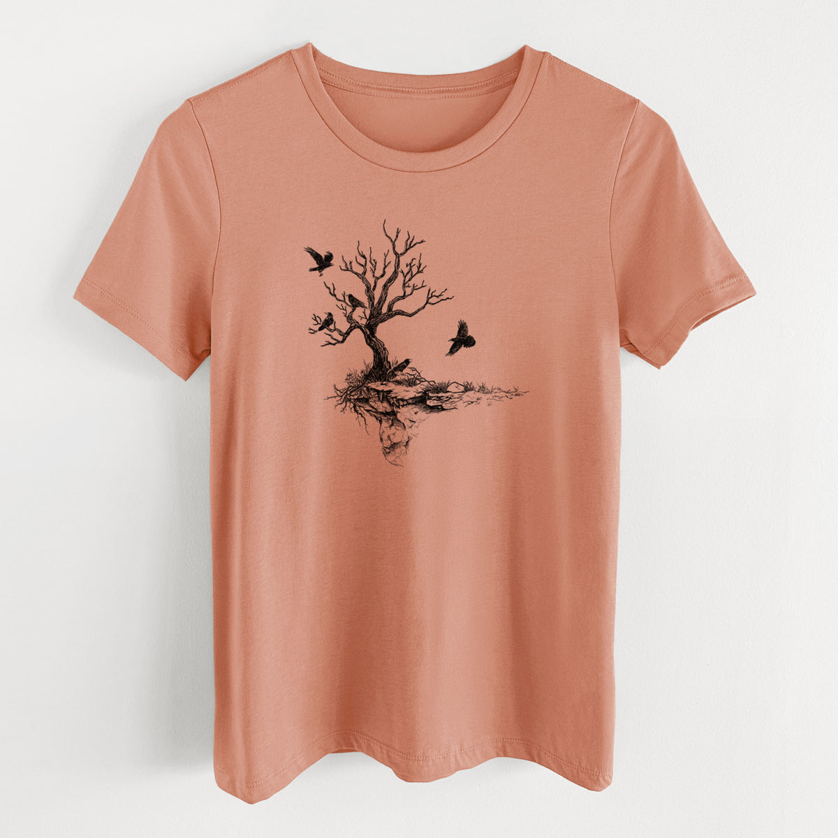 Terracotta orange women's relaxed fit cotton t-shirt laid flat, printed with a black ink illustration of a bare twisted tree on a small island with ravens flying around it.