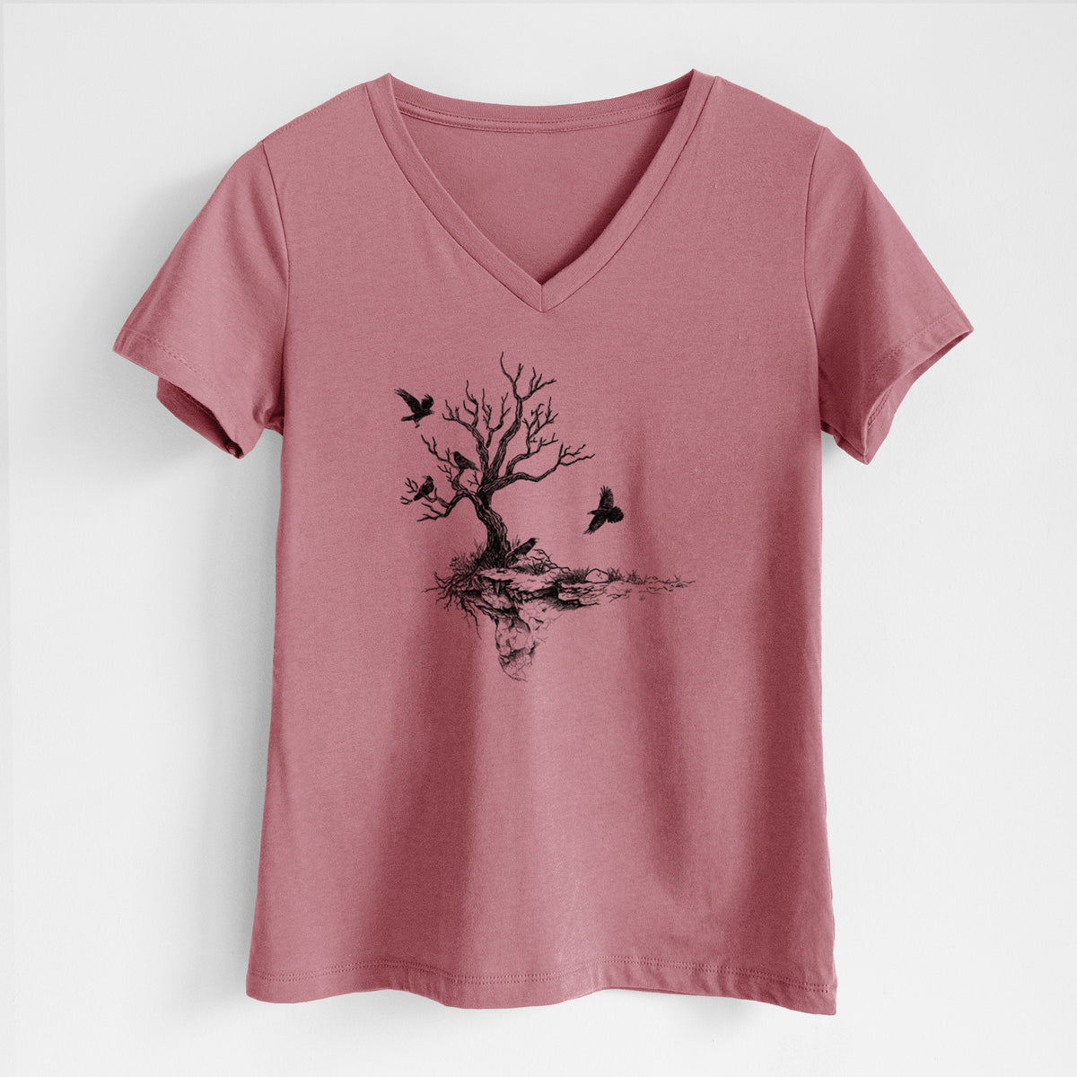 Mauve pink women's relaxed fit cotton V-neck t-shirt laid flat, printed with a black ink illustration of a bare twisted tree on a small island with ravens flying around it.