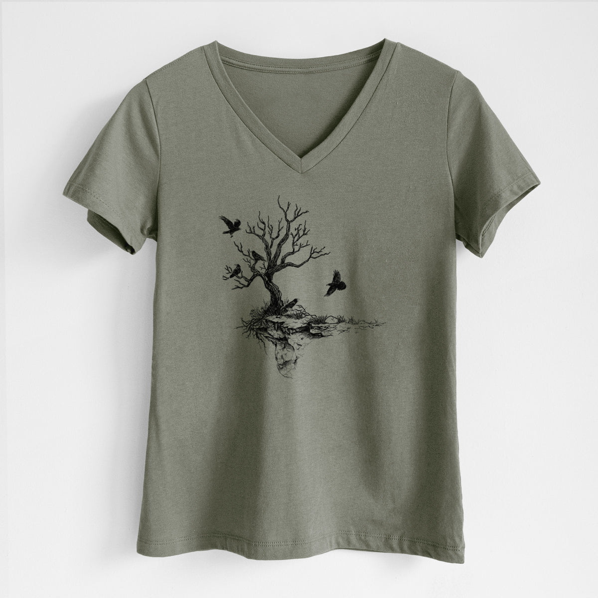 Military green women's relaxed fit cotton V-neck t-shirt laid flat, printed with a black ink illustration of a bare twisted tree on a small island with ravens flying around it.