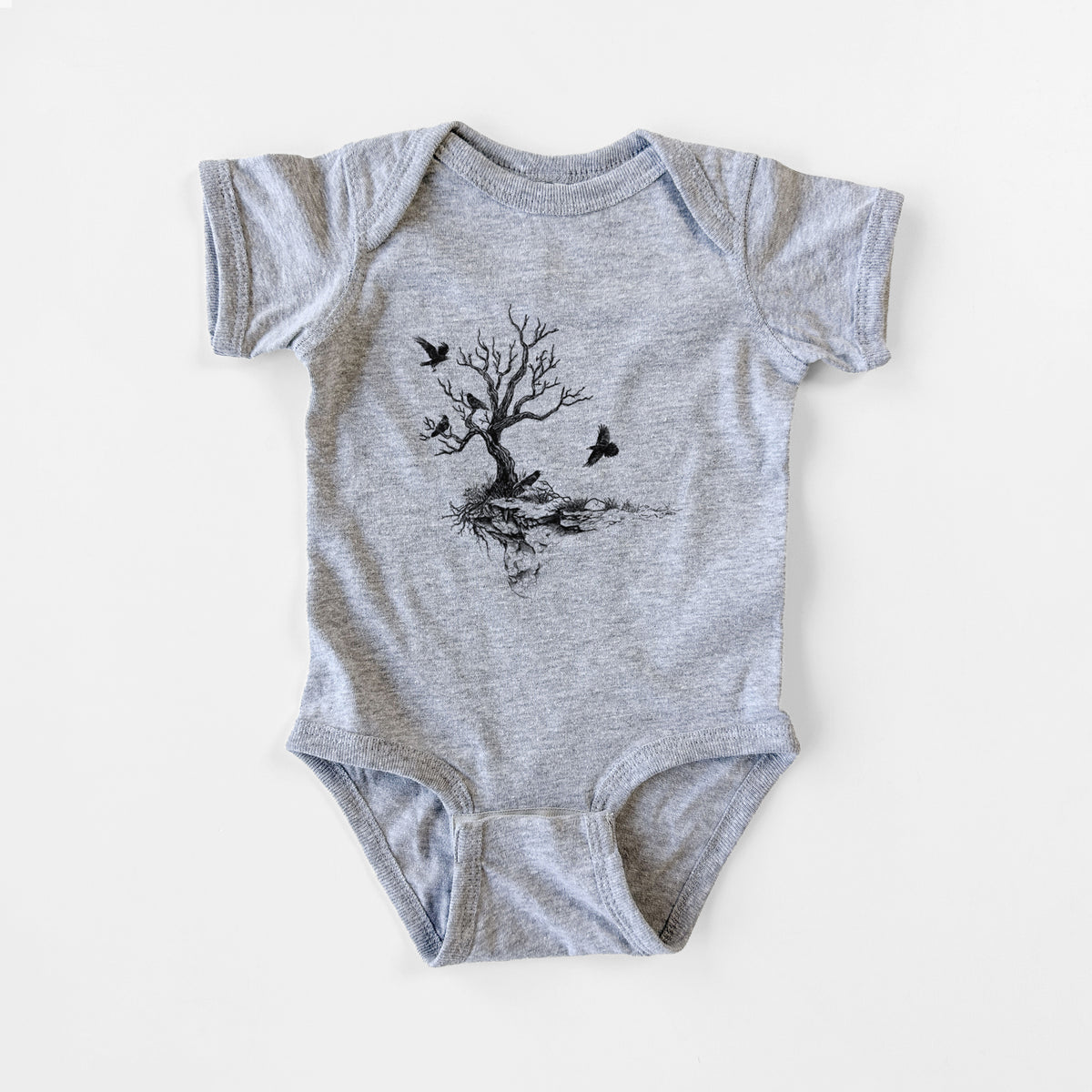 Grey baby bodysuit laid flat, printed with a black ink illustration of a bare twisted tree on a small island with ravens flying around it.