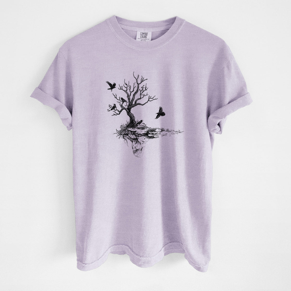 Orchid purple Comfort Colors t-shirt laid flat, printed with a black ink illustration of a bare twisted tree on a small island with ravens flying around it.