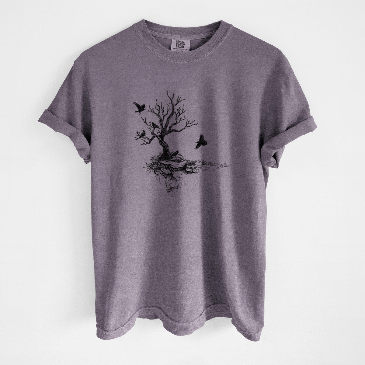 Wine red Comfort Colors t-shirt laid flat, printed with a black ink illustration of a bare twisted tree on a small island with ravens flying around it.