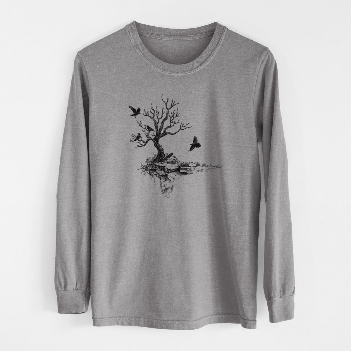 Grey Comfort Colors long sleeve shirt laid flat, printed with a black ink illustration of a bare twisted tree on a small island with ravens flying around it.