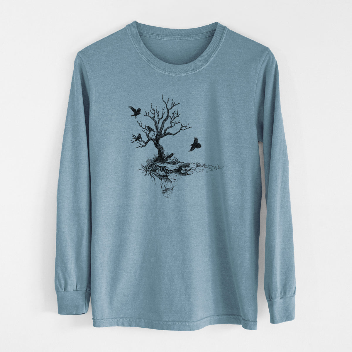 Steel blue Comfort Colors long sleeve shirt laid flat, printed with a black ink illustration of a bare twisted tree on a small island with ravens flying around it.