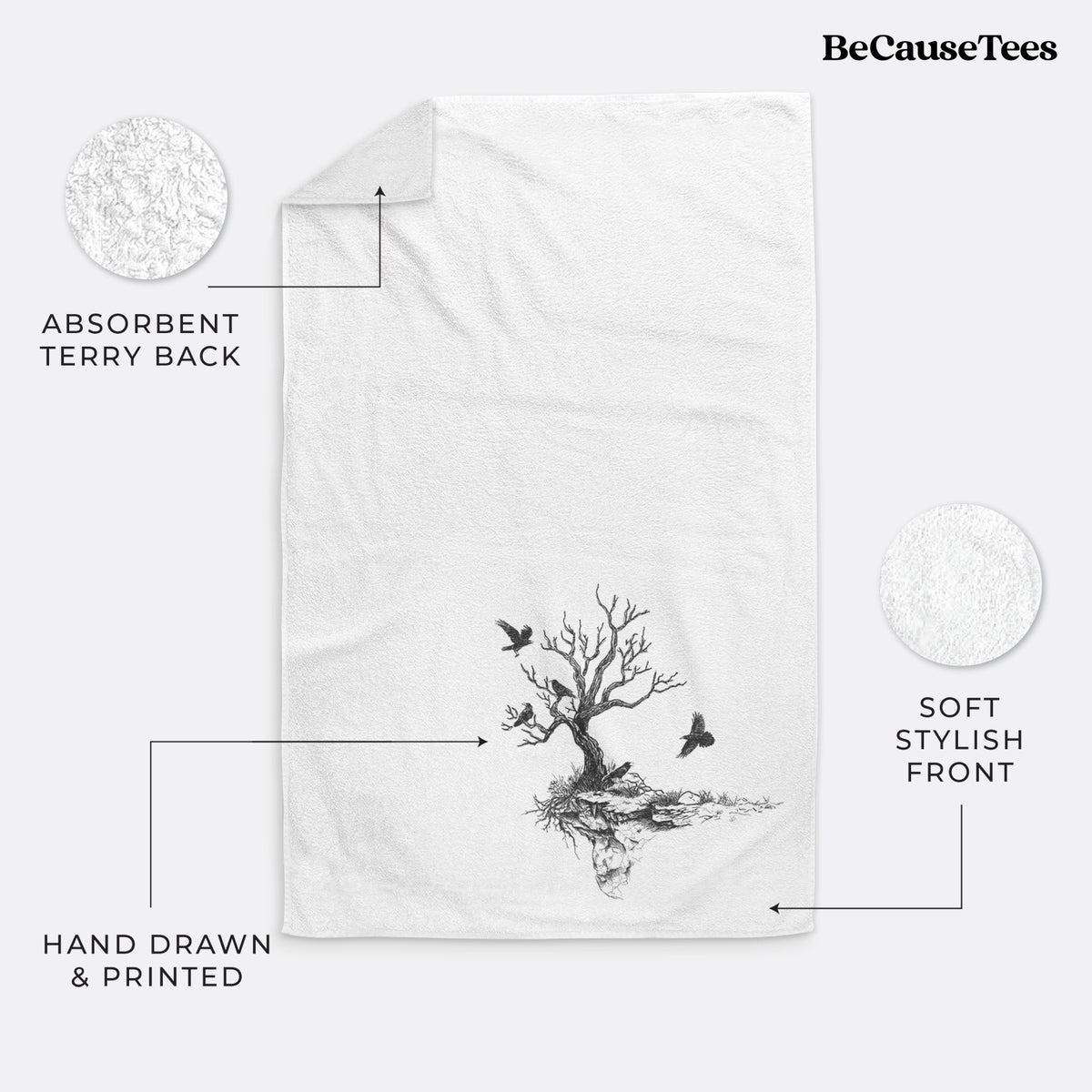 White hand towel printed with a black ink illustration of a bare twisted tree on a small island with ravens flying around it.