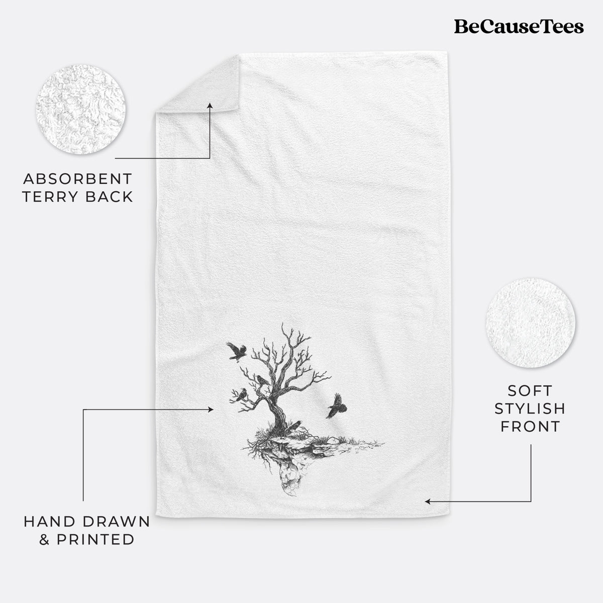 White hand towel printed with a black ink illustration of a bare twisted tree on a small island with ravens flying around it.