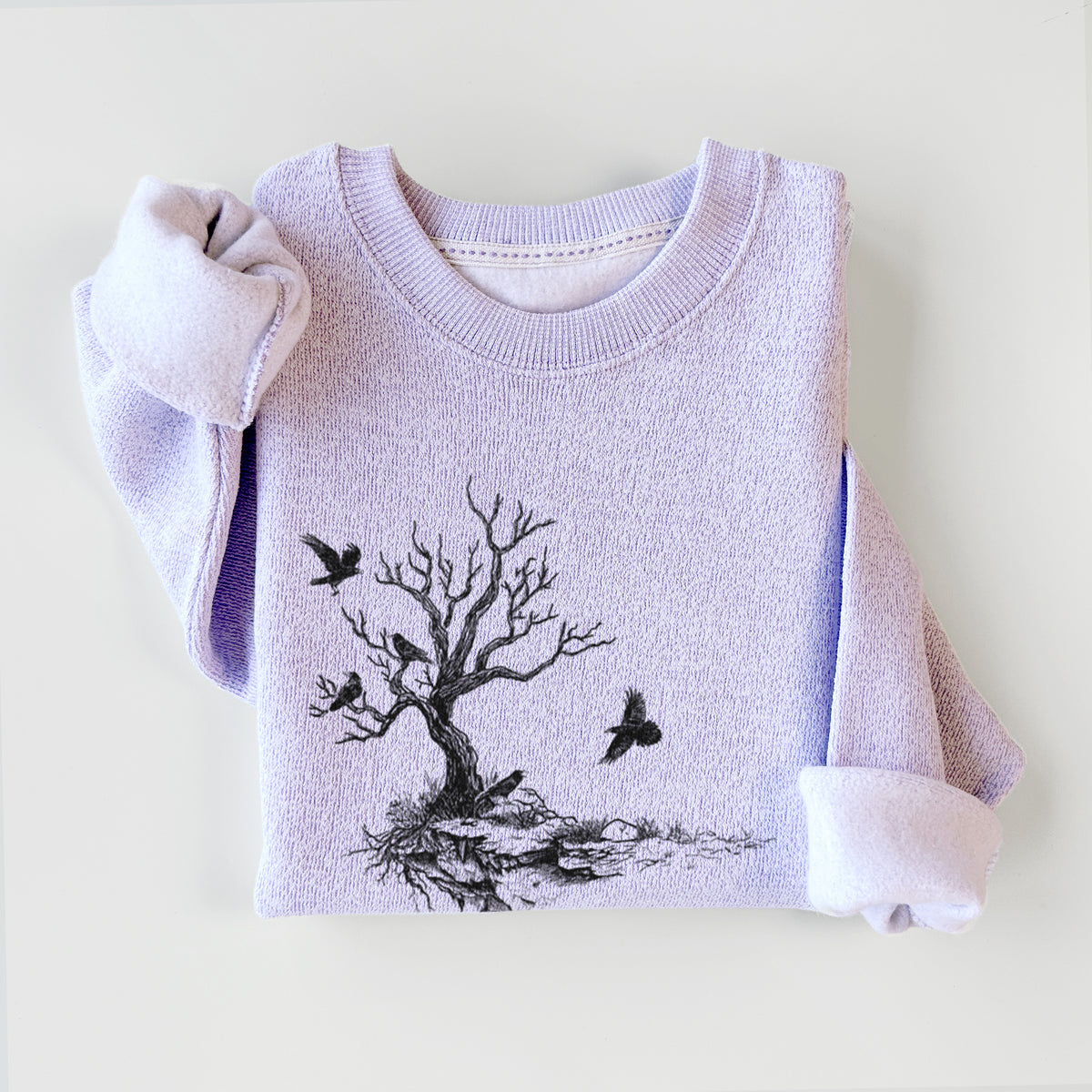 Ice purple knit sweatshirt printed with a black ink illustration of a bare twisted tree on a small island with ravens flying around it, styled flat.