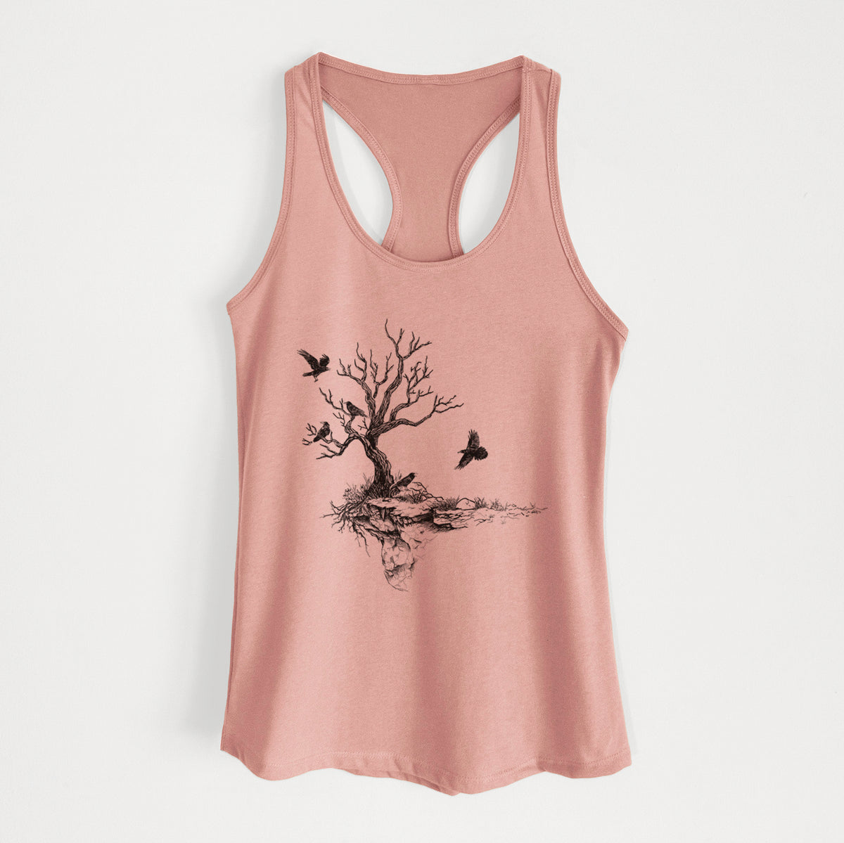 Desert pink women's racerback tank top laid flat, printed with a black ink illustration of a bare twisted tree on a small island with ravens flying around it.