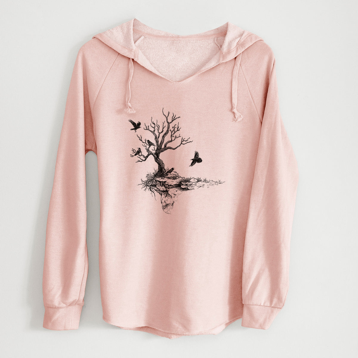 Blush pink women's Cali Wave hooded sweatshirt laid flat, printed with a black ink illustration of a bare twisted tree on a small island with ravens flying around it.