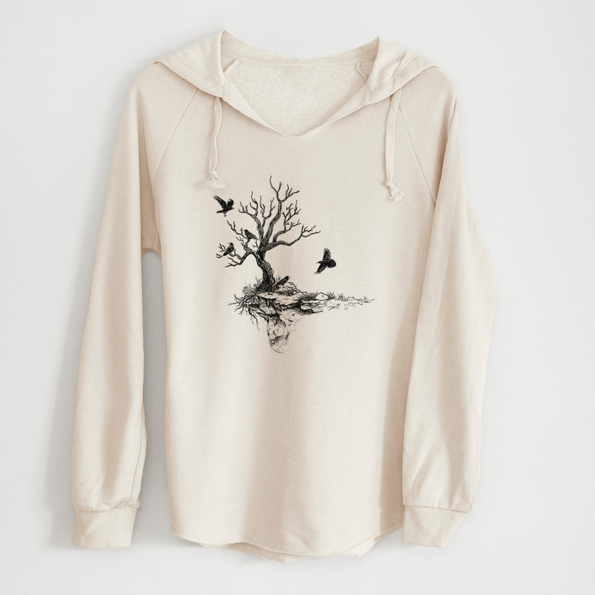 Bone cream women's Cali Wave hooded sweatshirt laid flat, printed with a black ink illustration of a bare twisted tree on a small island with ravens flying around it.
