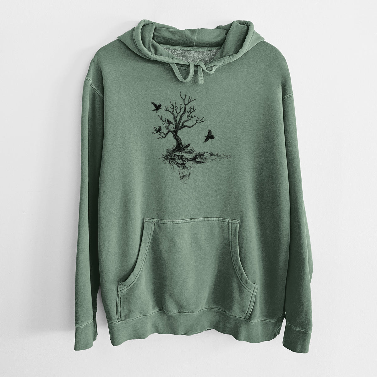 Alpine green pigment dyed hoodie laid flat, printed with a black ink illustration of a bare twisted tree on a small island with ravens flying around it.