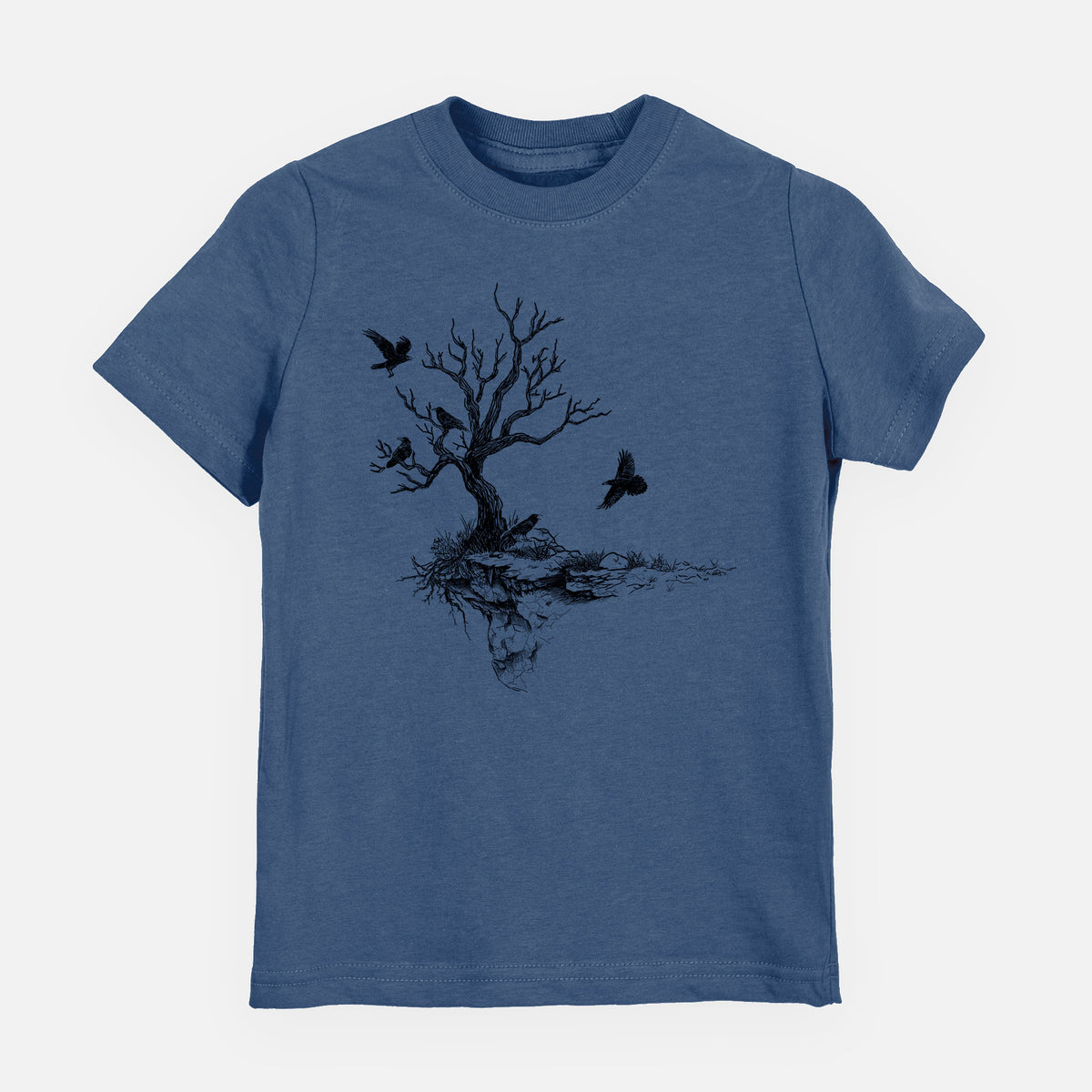 Indigo blue youth t-shirt laid flat, printed with a black ink illustration of a bare twisted tree on a small island with ravens flying around it.