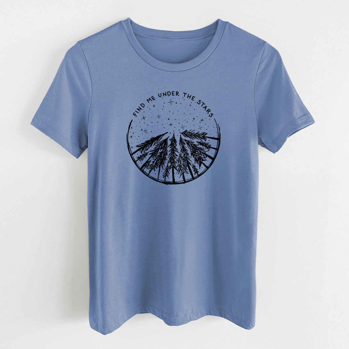 Blue bell women's relaxed fit cotton t-shirt laid flat, printed with a circle of pine trees under a starry sky, with the words Find Me Under the Stars.