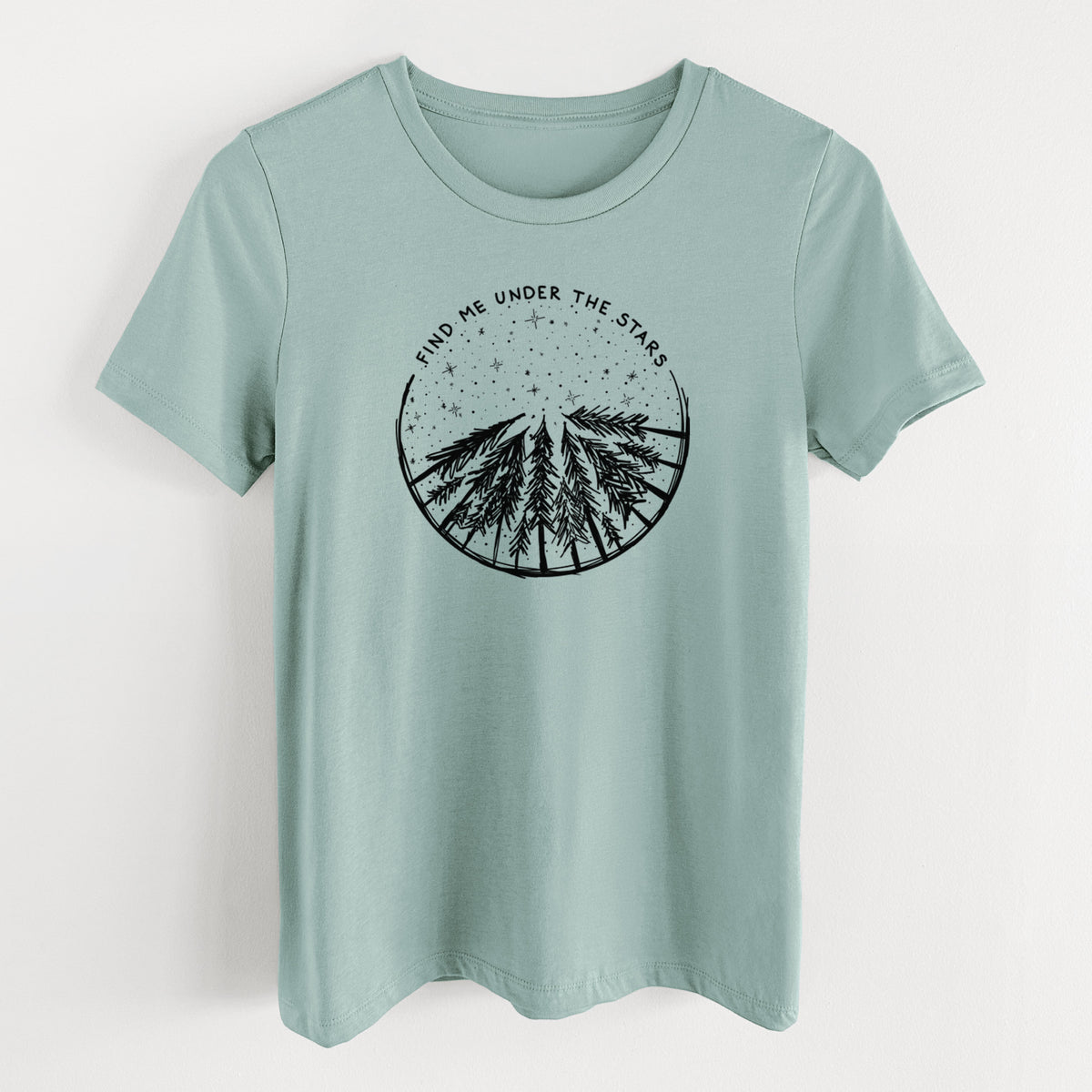 Dusty blue women's relaxed fit cotton t-shirt laid flat, printed with a circle of pine trees under a starry sky, with the words Find Me Under the Stars.