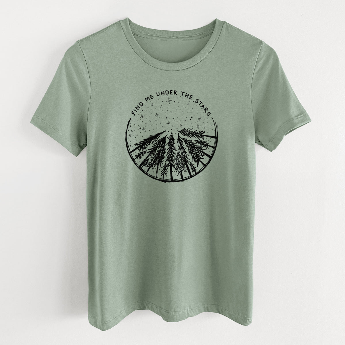 Sage green women's relaxed fit cotton t-shirt laid flat, printed with a circle of pine trees under a starry sky, with the words Find Me Under the Stars.