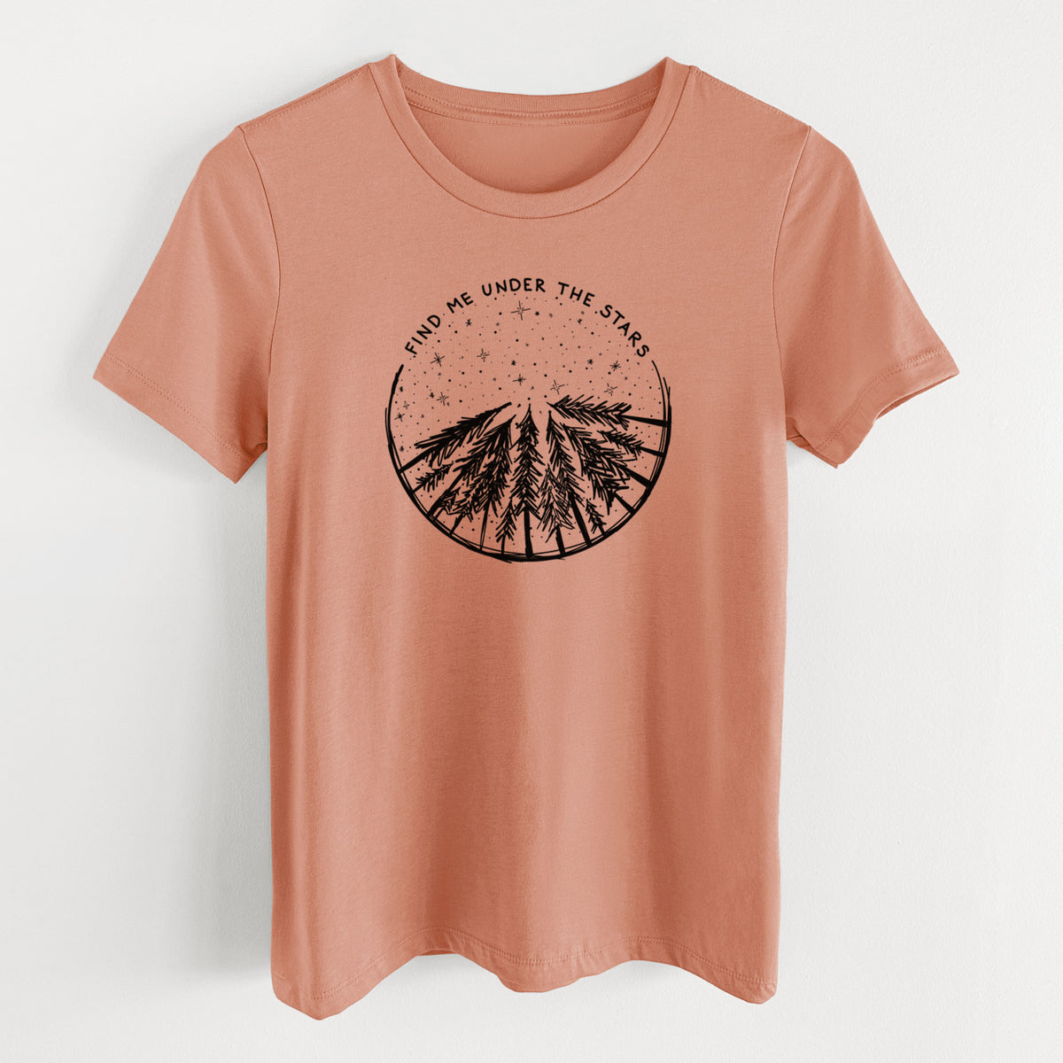 Terracotta orange women's relaxed fit cotton t-shirt laid flat, printed with a circle of pine trees under a starry sky, with the words Find Me Under the Stars.