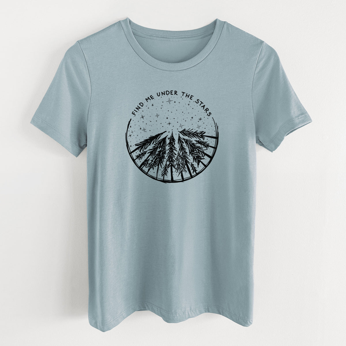 Vintage denim women's relaxed fit cotton t-shirt laid flat, printed with a circle of pine trees under a starry sky, with the words Find Me Under the Stars.