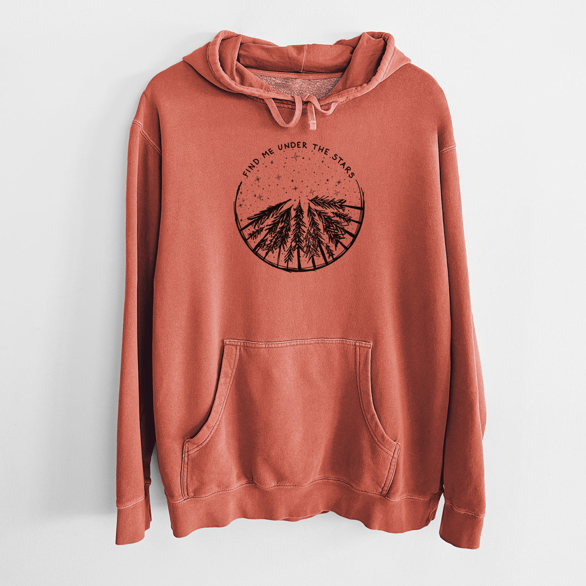 Amber orange pigment dyed hoodie laid flat, printed with a circle of pine trees under a starry sky, with the words Find Me Under the Stars.