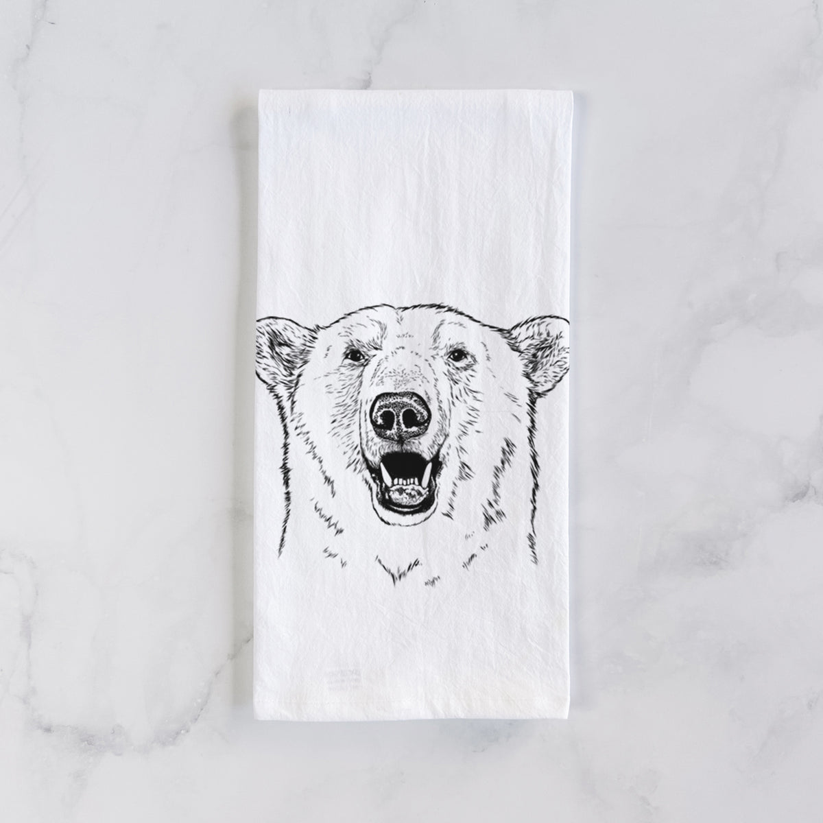 White cotton tea towel laid flat on marble, printed with a black ink portrait of a smiling polar bear's face.