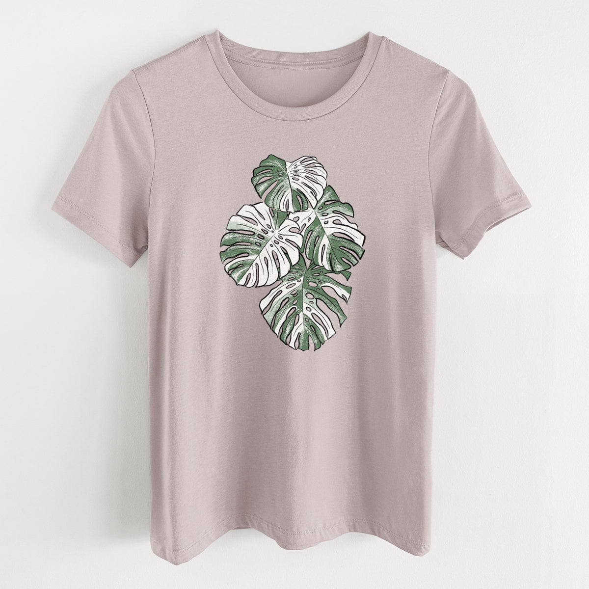 Pink gravel women's relaxed fit cotton t-shirt laid flat, printed with a full-color illustration of a variegated Monstera leaf in green and white.