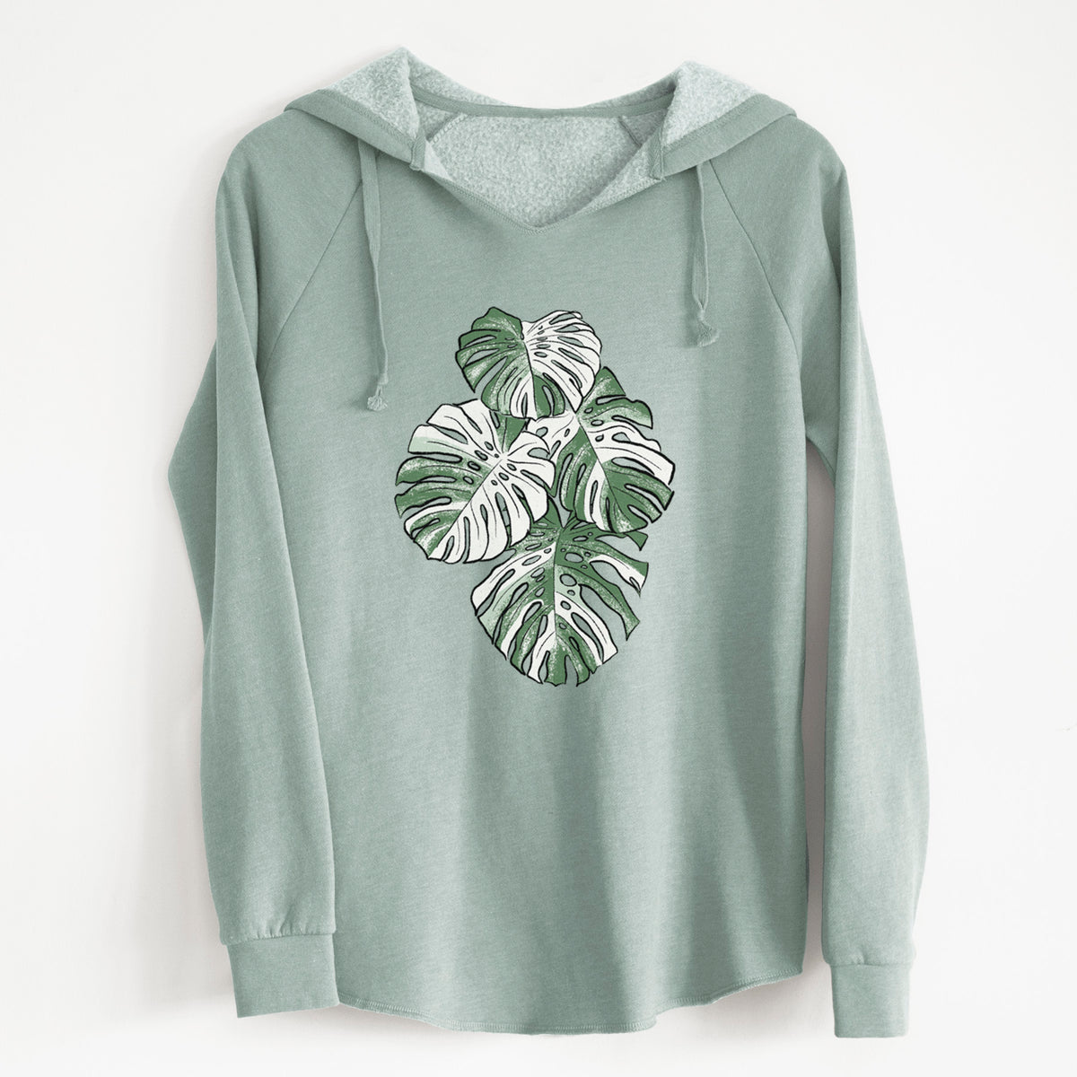 Sage green women's Cali Wave hooded sweatshirt laid flat, printed with a full-color illustration of a variegated Monstera leaf in green and white.