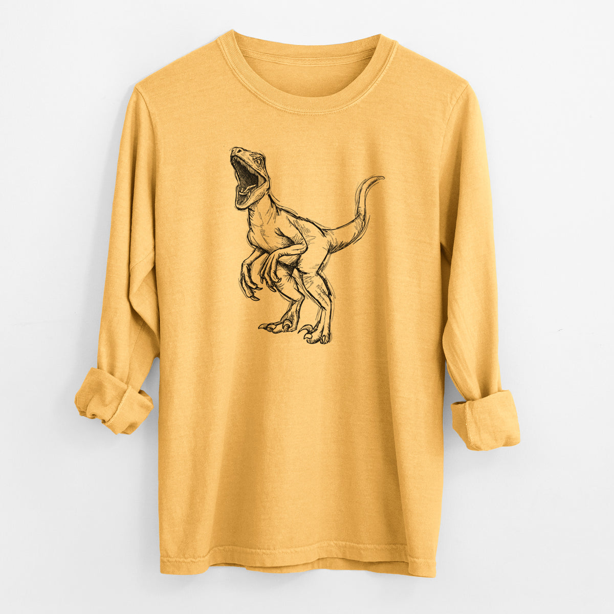 Golden wheat yellow Comfort Colors long sleeve shirt laid flat with the cuffs rolled, printed with a black ink illustration of a Velociraptor roaring.