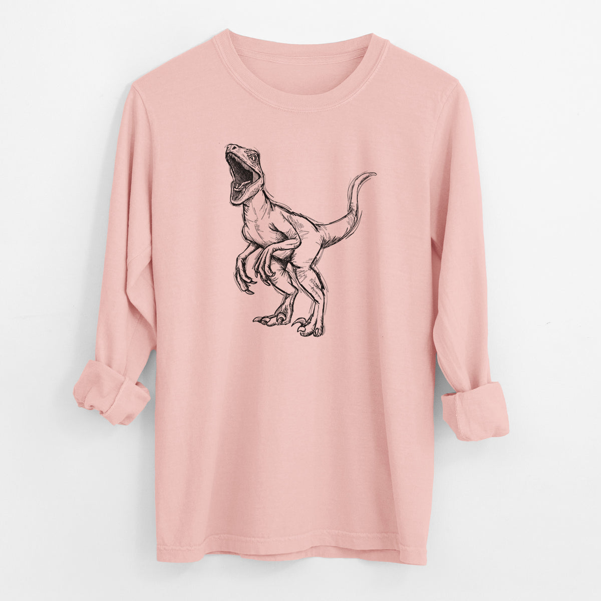 Peachy Comfort Colors long sleeve shirt laid flat with the cuffs rolled, printed with a black ink illustration of a Velociraptor roaring.