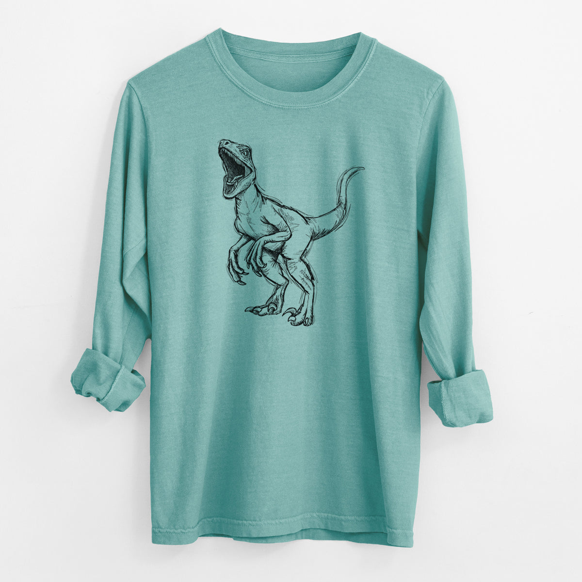 Reef green Comfort Colors long sleeve shirt laid flat with the cuffs rolled, printed with a black ink illustration of a Velociraptor roaring.