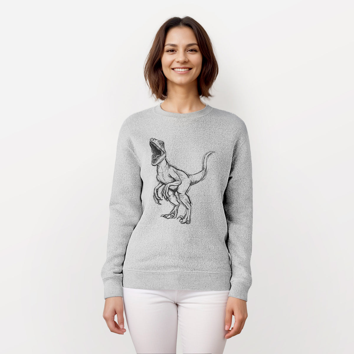 Woman wearing a knit sweatshirt printed with a black ink illustration of a Velociraptor roaring.