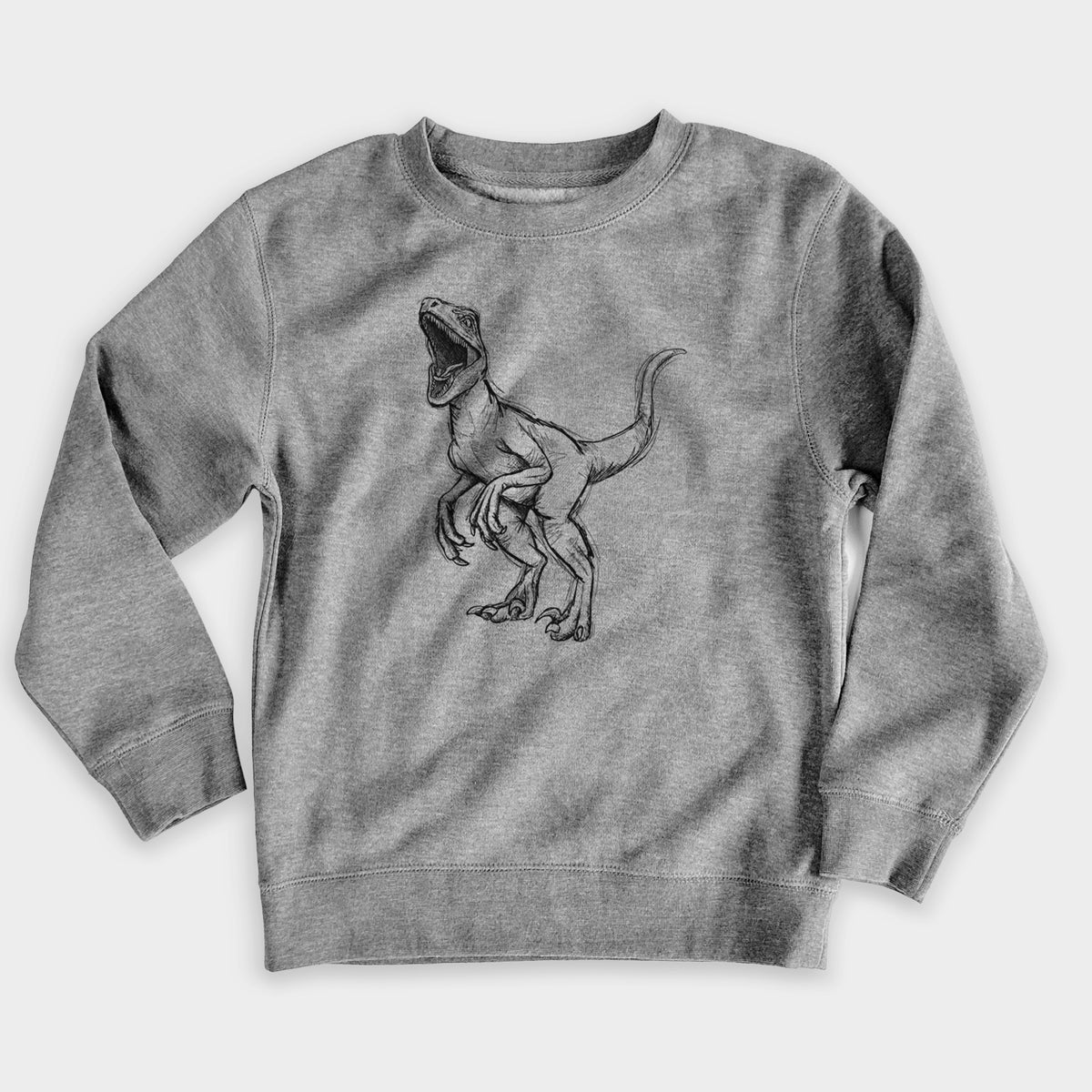 Nickel grey youth crewneck sweatshirt laid flat, printed with a black ink illustration of a Velociraptor roaring.