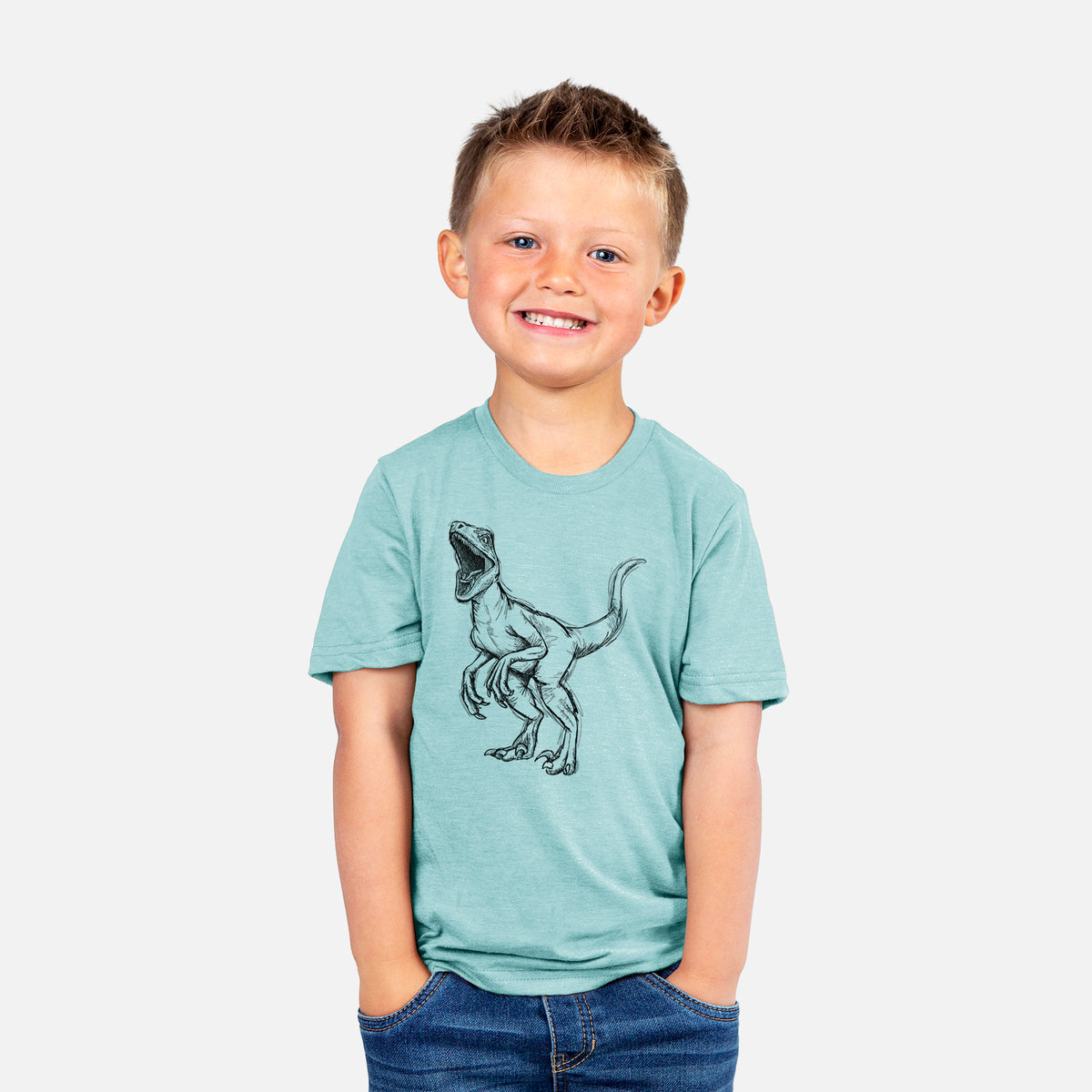 Smiling boy wearing a youth t-shirt printed with a black ink illustration of a Velociraptor roaring.
