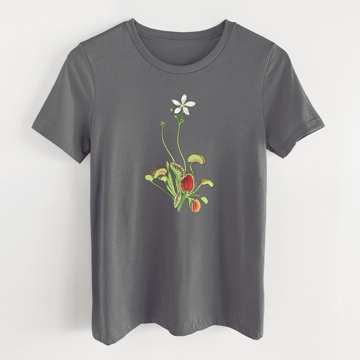 Asphalt women's relaxed fit cotton t-shirt laid flat, printed with a full-color illustration of a Venus flytrap plant with red traps and a small white flower.