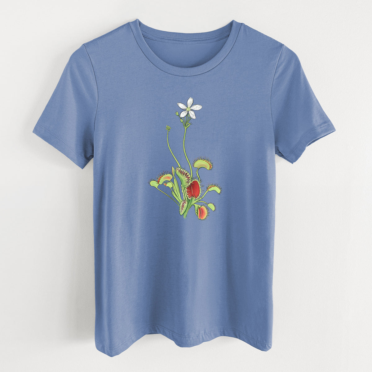 Blue bell women's relaxed fit cotton t-shirt laid flat, printed with a full-color illustration of a Venus flytrap plant with red traps and a small white flower.