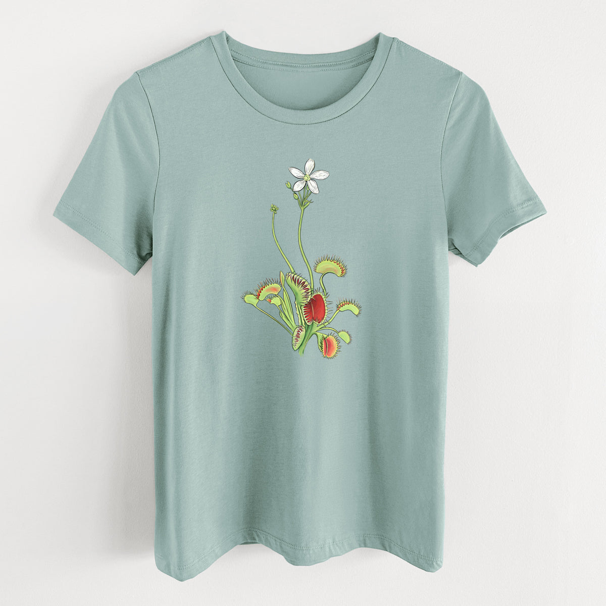Dusty blue women's relaxed fit cotton t-shirt laid flat, printed with a full-color illustration of a Venus flytrap plant with red traps and a small white flower.