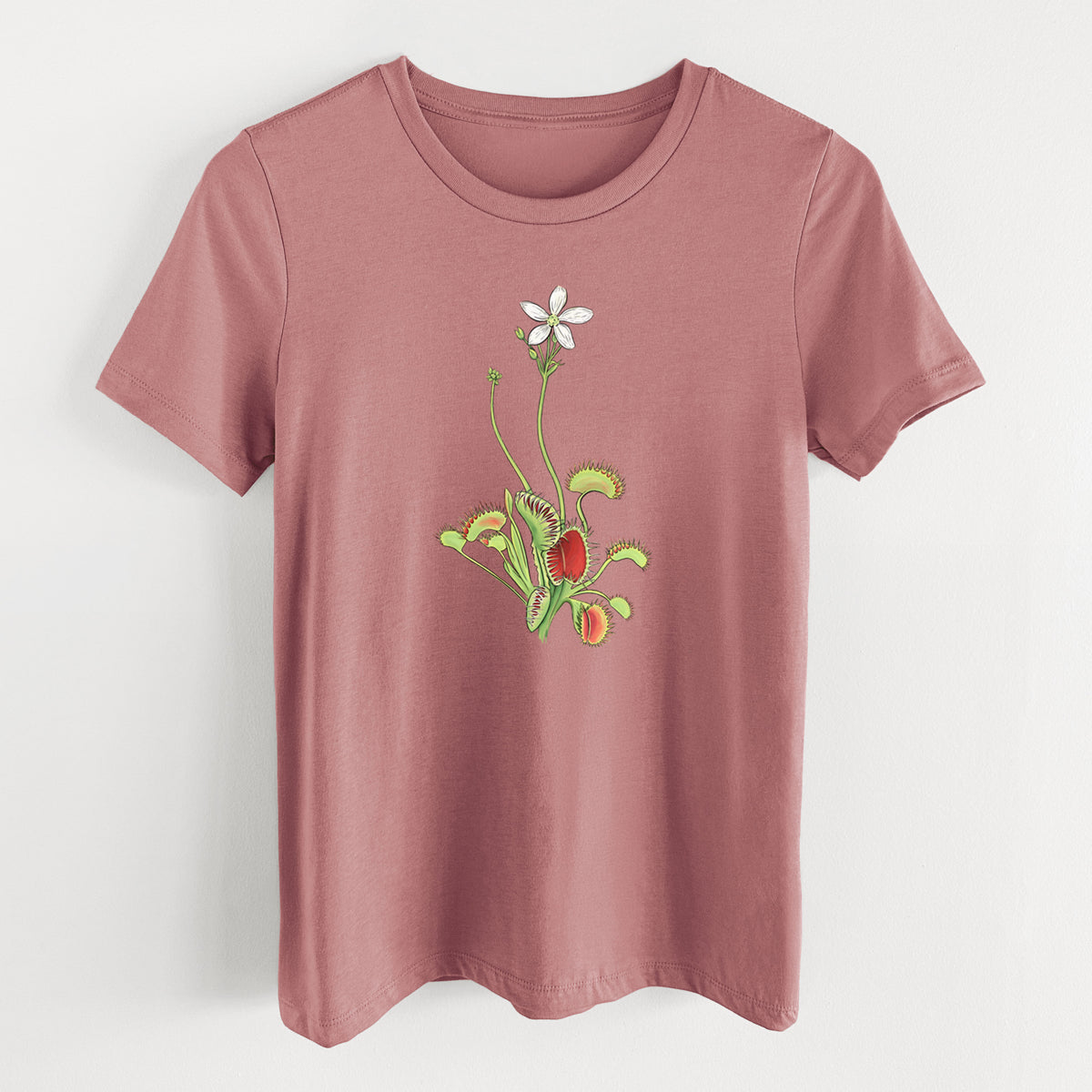 Mauve pink women's relaxed fit cotton t-shirt laid flat, printed with a full-color illustration of a Venus flytrap plant with red traps and a small white flower.