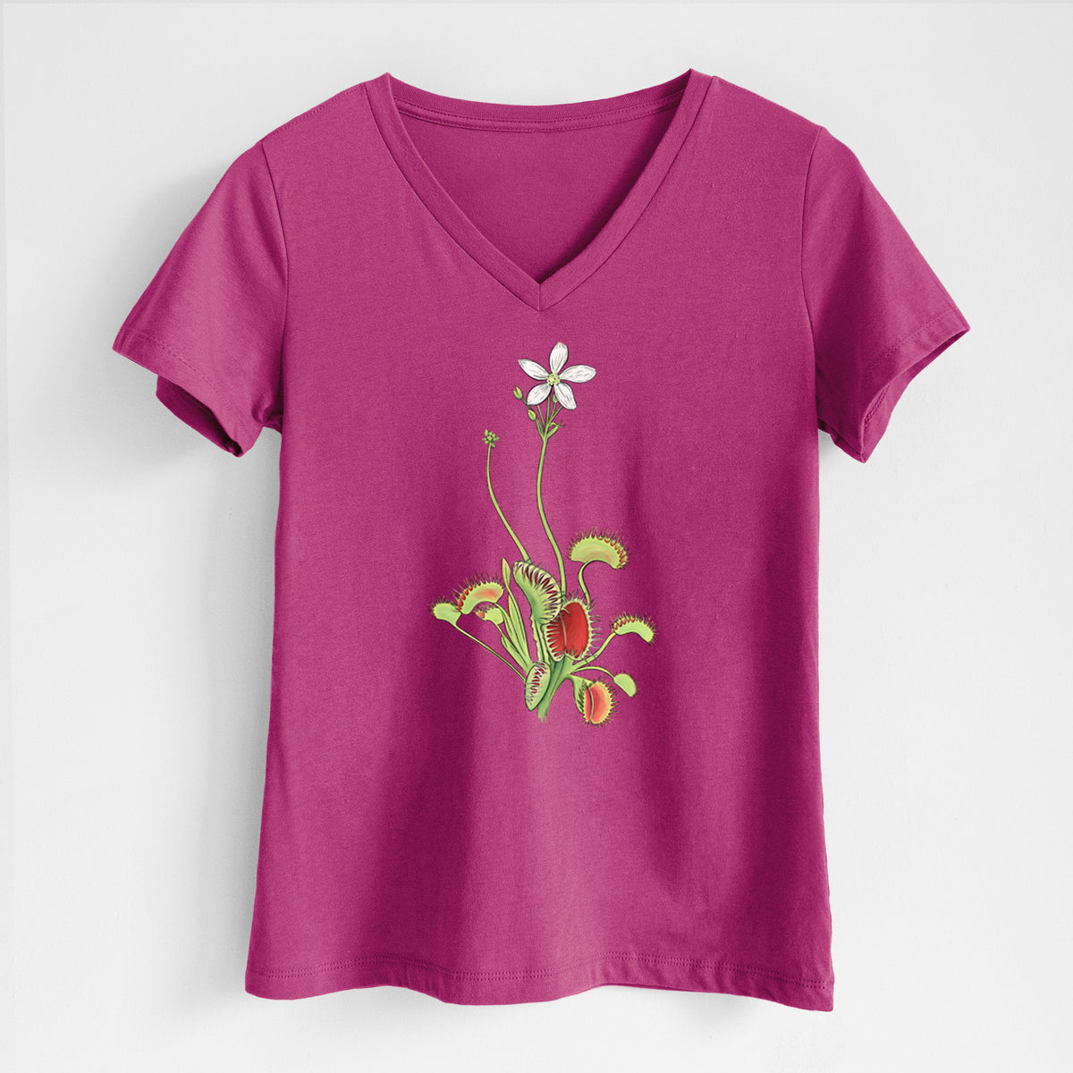 Berry pink women's relaxed fit cotton V-neck t-shirt laid flat, printed with a full-color illustration of a Venus flytrap plant with red traps and a small white flower.