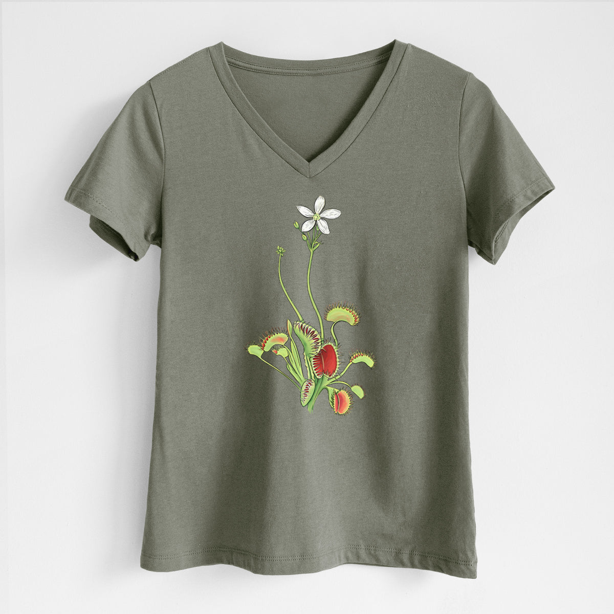 Military green women's relaxed fit cotton V-neck t-shirt laid flat, printed with a full-color illustration of a Venus flytrap plant with red traps and a small white flower.