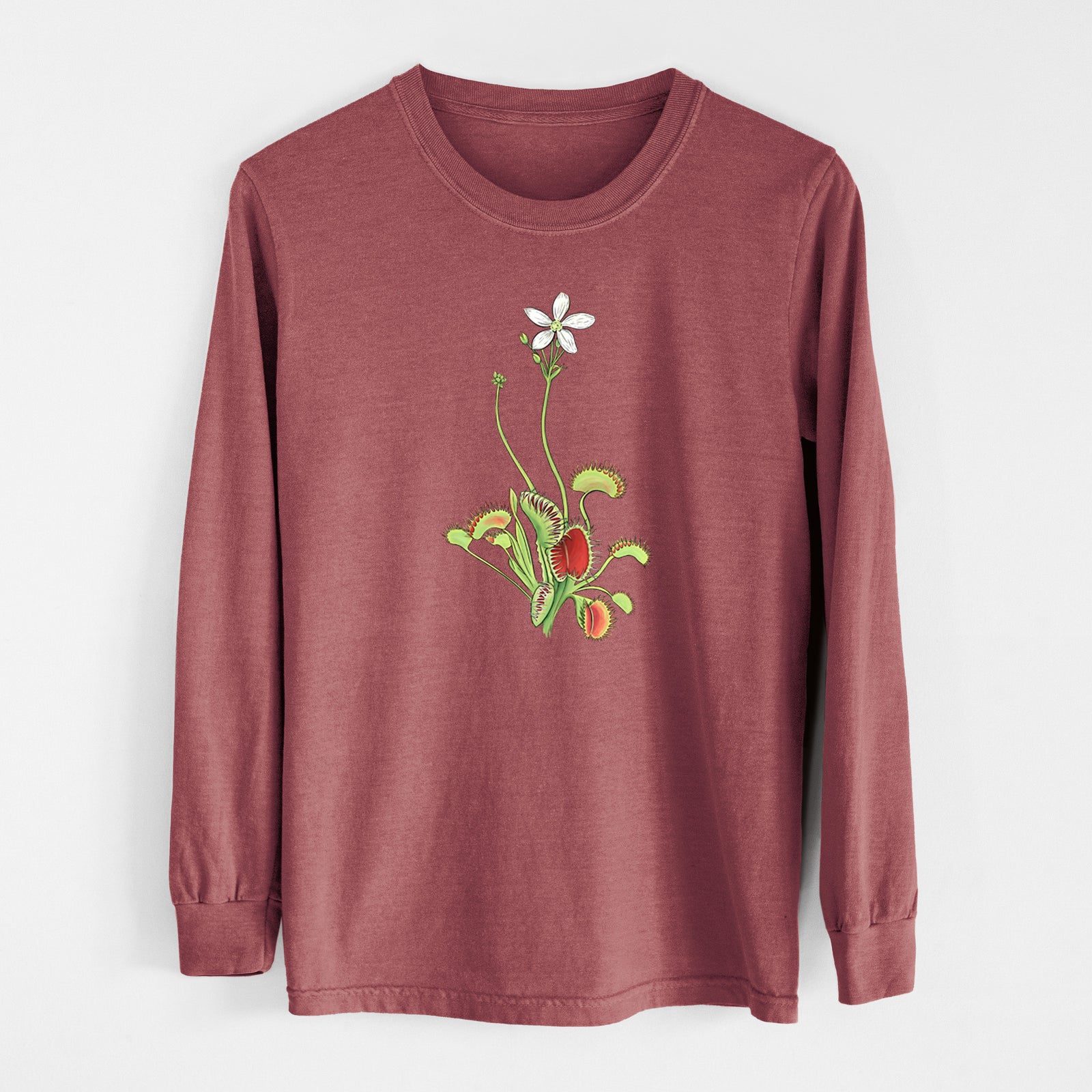 Ivory Comfort Colors long sleeve shirt laid flat, printed with a full-color illustration of a Venus flytrap plant with red traps and a small white flower.