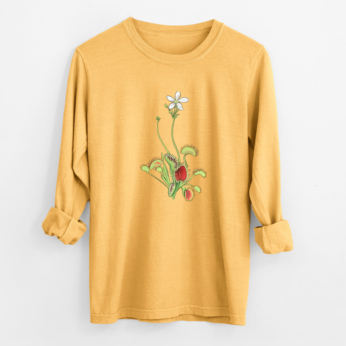 Golden wheat yellow Comfort Colors long sleeve shirt laid flat with the cuffs rolled, printed with a full-color illustration of a Venus flytrap plant with red traps and a small white flower.