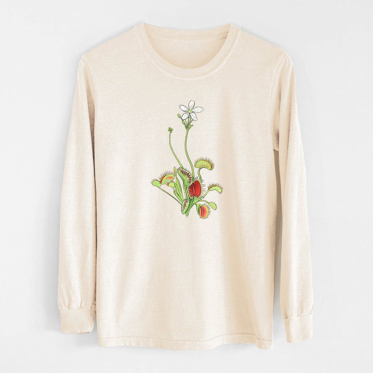 Ivory Comfort Colors long sleeve shirt laid flat, printed with a full-color illustration of a Venus flytrap plant with red traps and a small white flower.